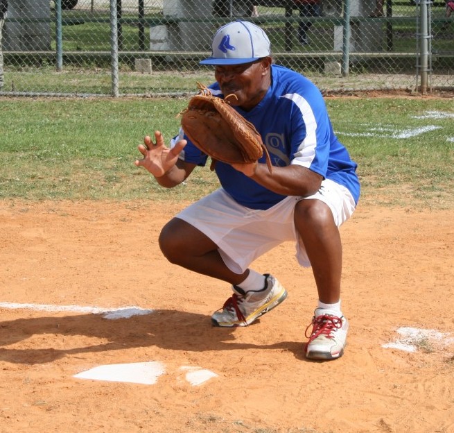 Batting coach Gerald Covington catches the first pitch before the game.